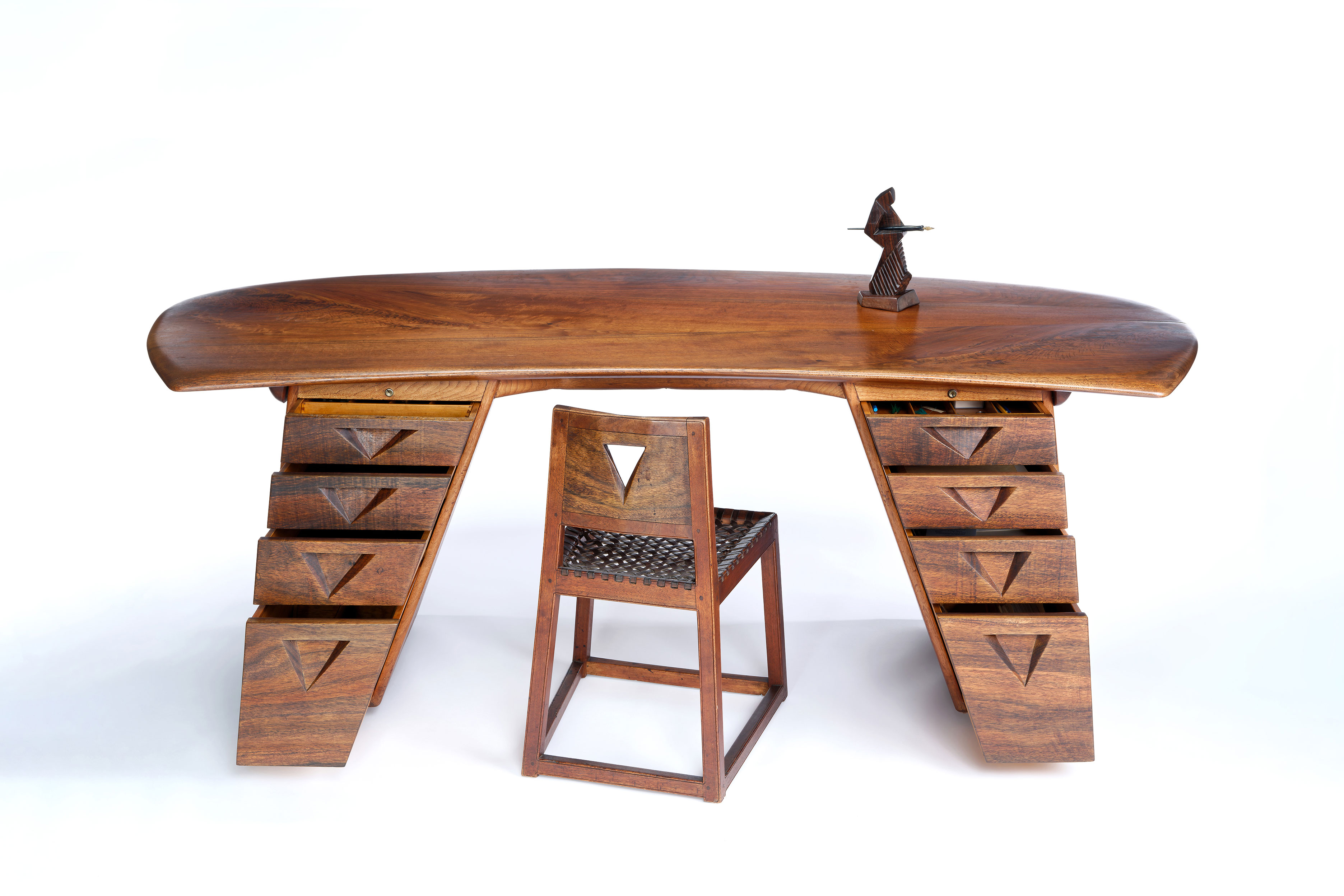 Wharton Esherick, Flat Top Desk, 1929 and 1962. Walnut and padouk, 28 x 82 x 36 in. Desk Chair, 1929. Walnut, padouk, laced leather seat, 28 x 18 x 18 in. Desk Figure, Bronze casting of 1929 Cocobolo original, 10 x 5 x 4 in. Wharton Esherick Museum Collection. Photo by Eoin O’Neill, courtesy of the Wharton Esherick Museum.